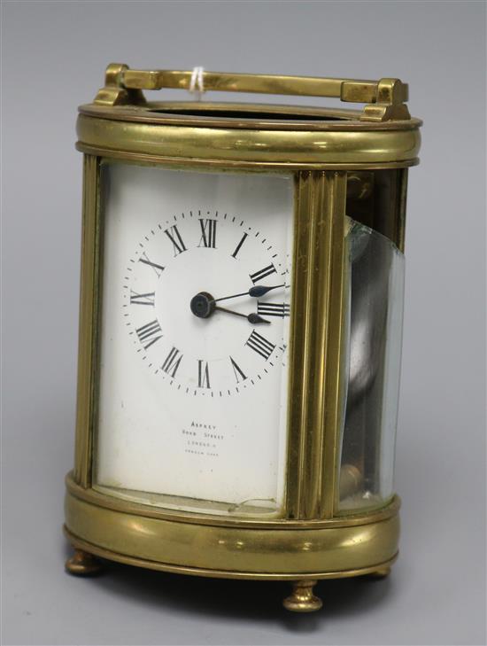 A 20th century oval brass carriage timepiece, the Roman dial marked Asprey London height 13cm - (In need of restoration)